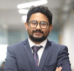 Confident man in a suit standing in a modern office, showcasing professionalism.