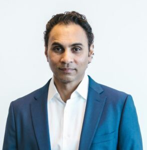 Portrait of a confident businessman holding papers in formal attire inside an office